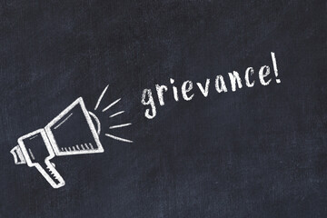 Chalk loudspeaker and inscription grievance on black chalkboard