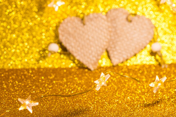 Two hearts on a gold background. Christmas decorations isolated on white. Out of focus.
