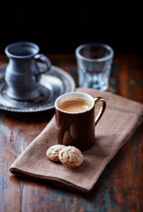 Cup of coffee with amaretti (Italian biscuits) on rustic wooden background.