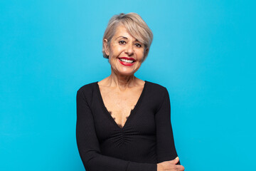middle age woman laughing shyly and cheerfully, with a friendly and positive but insecure attitude