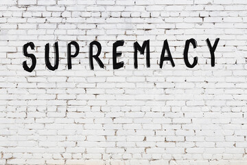 White wall with black paint inscription supremacy on it
