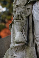 Hourglass in the hand of a grim reaper in a cemetery