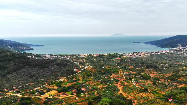 Aerial view of Aegean sea coast of Thassos, buildings, greenery, sea sxpanse on the background, Greece