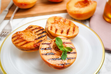 Delicious grilled peaches with mint on white table, closeup