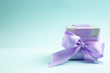 front view cute little present tied with purple bow on a blue background gift color new year christmas photo