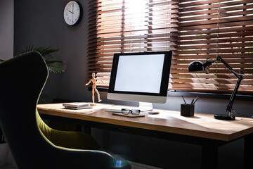 Stylish room interior with modern computer and comfortable office chair