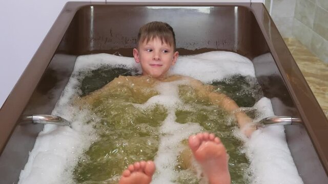 boy bathes. medical procedures hydrotherapy mineral water bubble bath 2020