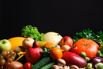 Assortment of fresh organic fruits and vegetables on black background