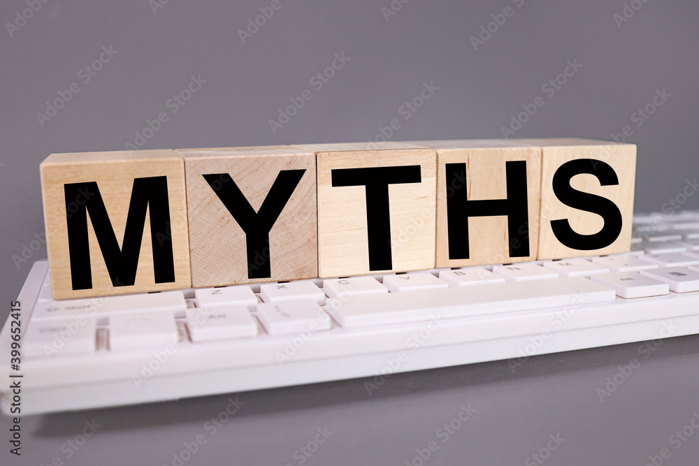 Fototapete myths word made with building blocks, business concept. text on wooden cubes on gray background on c