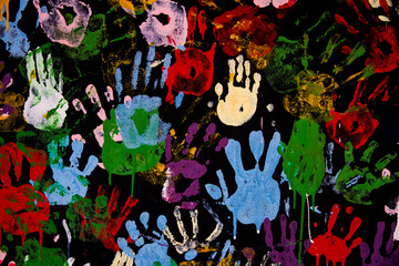 Seamless pattern of multicolored human handprints on the black wall. 