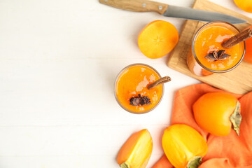 Tasty persimmon smoothie with anise and cinnamon on white wooden table, flat lay. Space for text