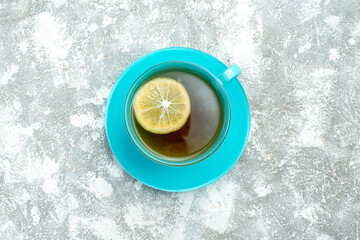 Obraz na płótnie Canvas top view cup of tea with lemon slice on light background drink photo color tea ceremony breakfast