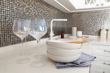 Beautiful ceramic dishware and glasses on countertop in modern kitchen
