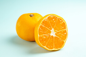 front close view fresh tangerine slices on light-blue background fruit color orange photo juice...