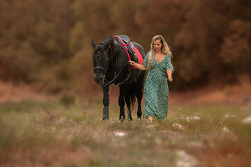 Fototapeta premium Woman in a dress with a black horse
