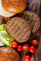 Making tasty vegetarian hamburgers from plant based grilled burgers, fresh bakes buns and organic vegetables
