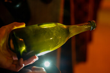 Checking of yeast in bottles, Champagne sparkling wine production in bottles in racks in...