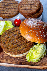 Making tasty vegetarian hamburgers from plant based grilled burgers, fresh bakes buns and organic vegetables