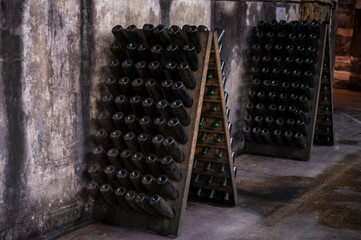 Champagne sparkling wine production in bottles in racks in underground cellar, Reims, Champagne, France