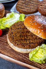 Making tasty vegetarian hamburgers from plant based grilled burgers, fresh bakes buns and organic vegetables
