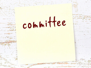 Yellow sticky note on wooden wall with handwritten word committee - obrazy, fototapety, plakaty