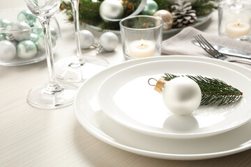 Festive table setting with beautiful dishware and Christmas decor on white wooden background