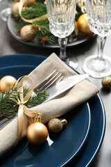 Festive table setting with beautiful dishware and Christmas decor on grey background