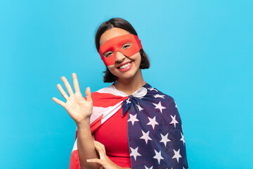 young latin woman smiling and looking friendly, showing number five or fifth with hand forward, counting down © kues1
