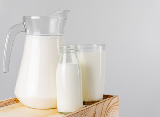A jug and bottle of  fresh milk glass on wooden crate box..Raw milk is high in calcium and protein to drink for all ages..Milk consumption nutritious and healthy dairy products concept.