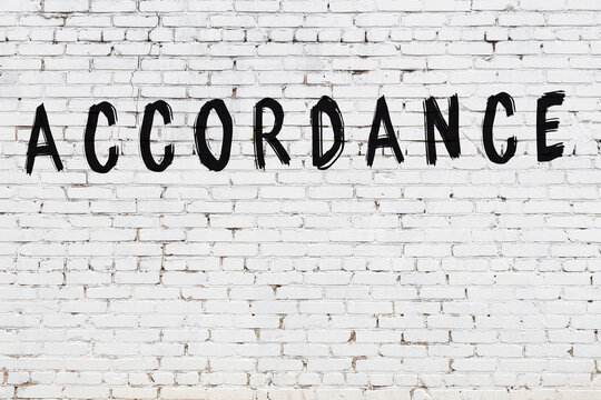 White wall with black paint inscription accordance on it