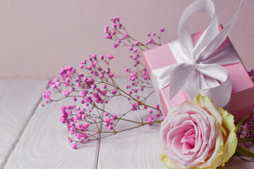 Obraz na płótnie Canvas Gift box with flowers on pink Valentine's Day background. Copyspace. anniversary, Mother's Day and birthday greetings, has a copy of the space