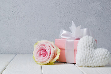 Gift box with pink rose and knitted white plush heart.the background of Valentine's Day. Copyspace.