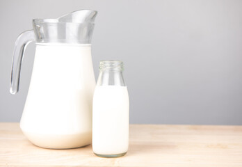 jug and bottle of fresh milk glass on wooden table background.  .Raw milk is high in calcium and protein to drink for all ages..Milk consumption nutritious and healthy dairy products concept.