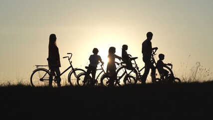 Fototapeta na wymiar A friendly large family with bicycles at sunset.