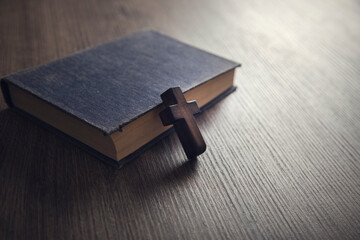 cross on the Bible on a wooden background