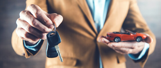 man hand car model with key  on dark background