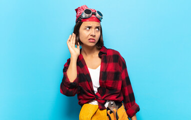 young latin woman looking serious and curious, listening, trying to hear a secret conversation or...