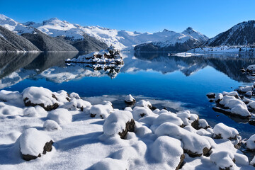 Clear lake, little island, mountains covered with fresh snow and frost.  Garibaldi Lake. Whistler. British Columbia. Canada 