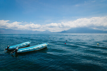 Two blue boats on lake Atitlan with view on volcanoe in Santa Cruz la Laguna, Guatemala
