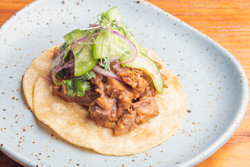 Gourmet Mexican shredded meat tacos on wooden table. Gourmet mexican food