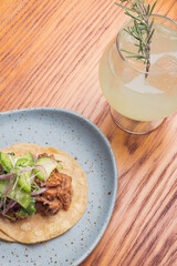 Gourmet Mexican shredded meat tacos on wooden table. Gourmet mexican food. Gourmet tacos and gin tonic.