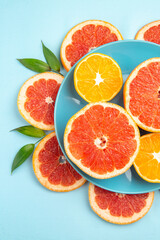 Naklejka na ściany i meble top view tasty grapefruits fruit slices on a blue background fresh citrus fruits juice mellow color