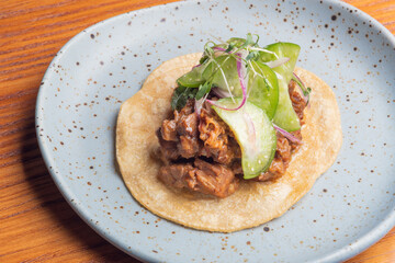 Gourmet Mexican shredded meat tacos on wooden table. Gourmet mexican food