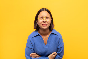 young latin woman feeling anxious, ill, sick and unhappy, suffering a painful stomach ache or flu