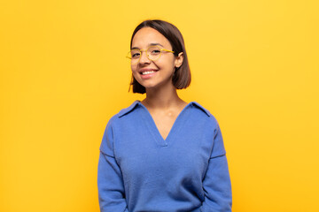 young latin woman with a big, friendly, carefree smile, looking positive, relaxed and happy,...