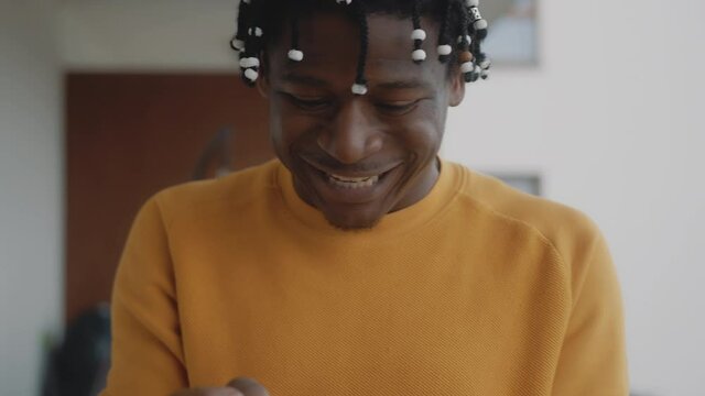 Portrait of african american black man receiving a good news. Reading text on the smartphone with winning gesture. High quality 4k footage