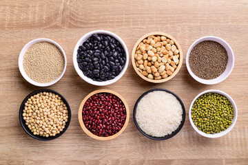 Various cereal grain in a bowl on wooden background (quinoa seeds, black kidney bean, peanut, perilla seeds, soybean, azuki beans, rice grain and mung beans)