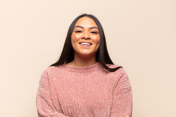 young latin woman laughing shyly and cheerfully, with a friendly and positive but insecure attitude