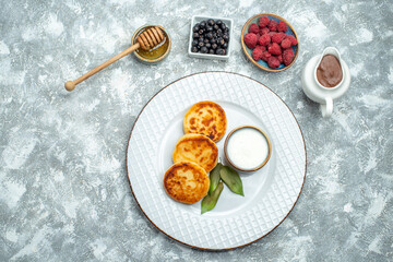 top view delicious muffins with berries on light background taste sugar photo sweet pancake dough fruits