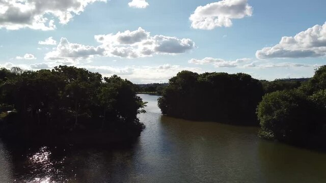 Voando sobre o lado e passando entre duas ilhas com &aacute;rvores e o por-do-sol ao fundo